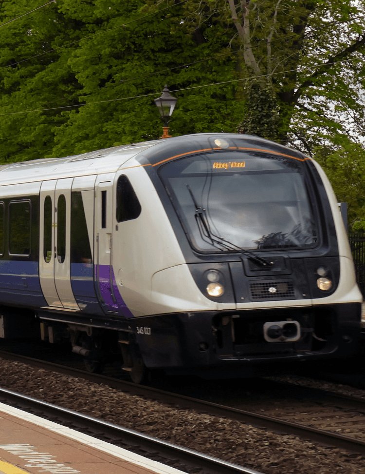 A train going past a train station going towards the camera