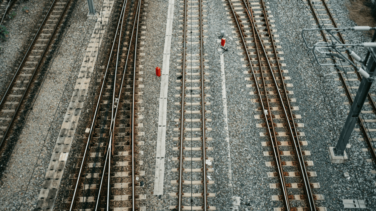 Aerial view of four different train tracks, two of them are at the track switch point.